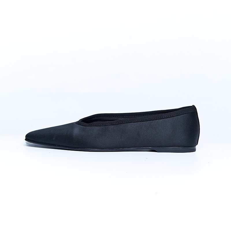 Minimal black leather flat with clean lines and low-profile silhouette for everyday designer footwear development
