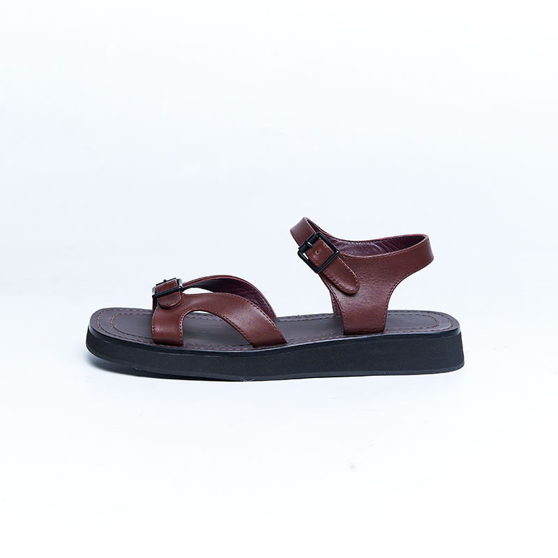 Brown leather flat sandal with double-strap construction and cushioned sole for casual designer footwear collections