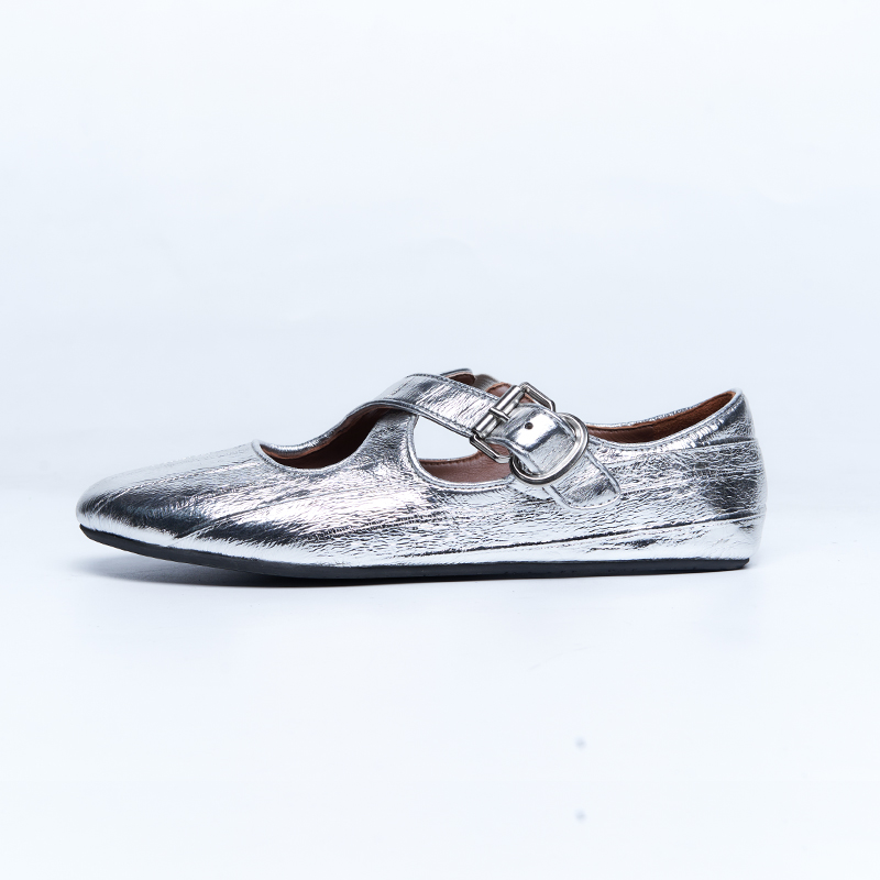Metallic silver Mary Jane flat with strap closure and structured upper, designed for contemporary women’s fashion footwear lines