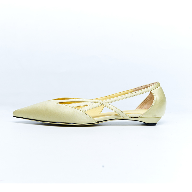 Light yellow leather flat with crossover strap design and refined pointed silhouette for women’s designer shoe development