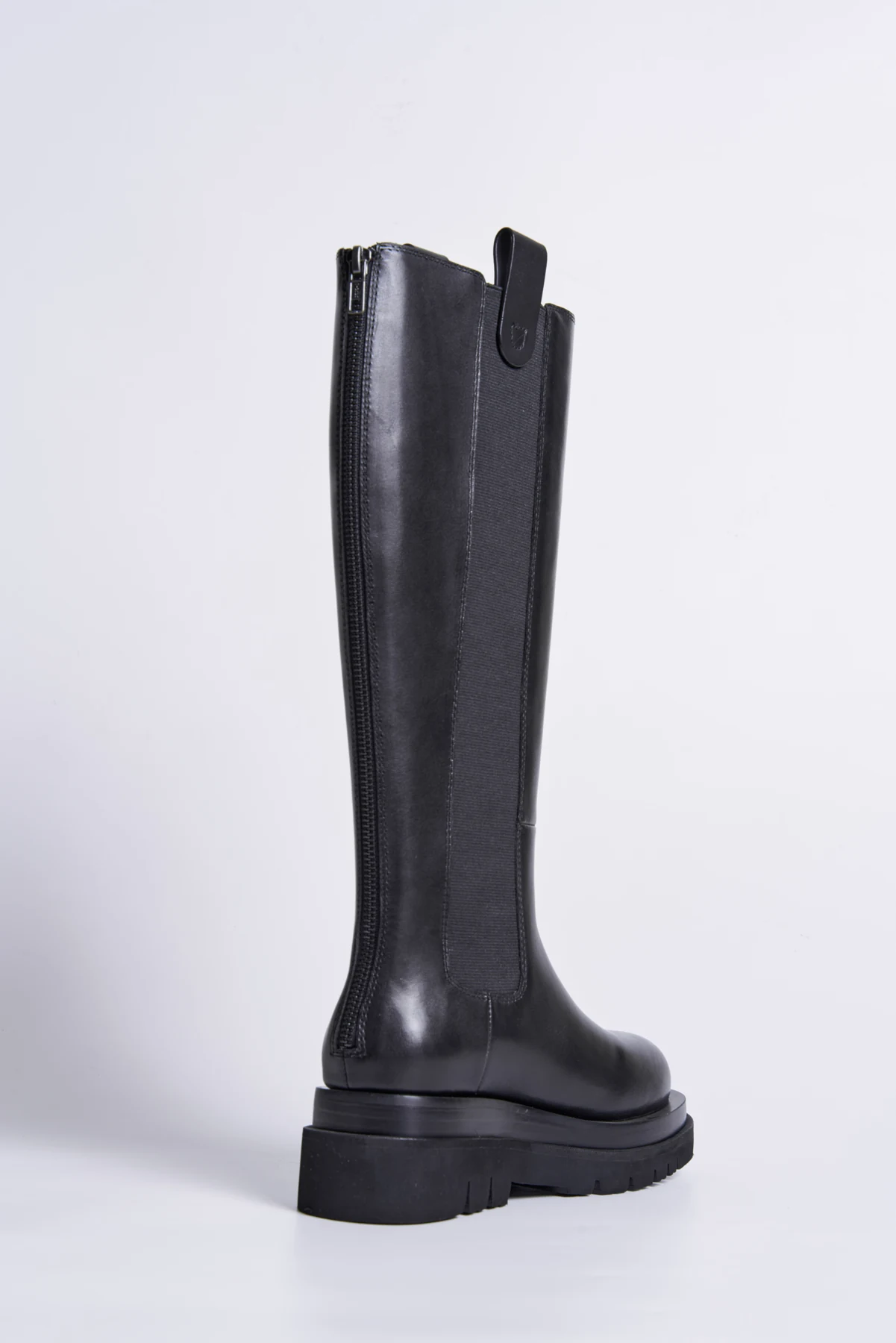 Black knee-high fashion boot showing modern proportion and construction